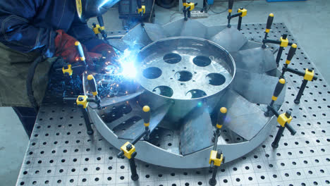 Workman-making-welding-of-channel-blades-of-huge-fan.-Production-of-motor