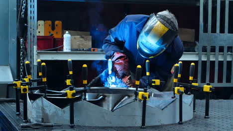 Welder-in-protective-uniform-conducting-welding-of-aircraft-engine-part
