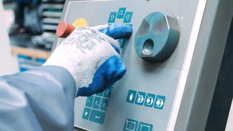 Worker-in-gloves-controlling-industrial-machine-by-pressing-membrane-buttons