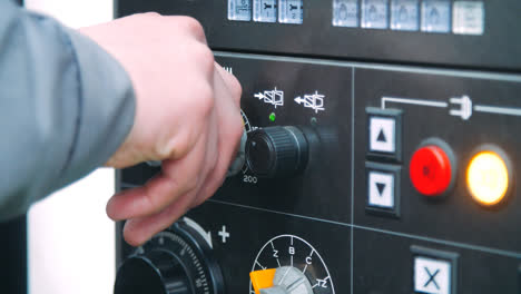 Engineer-rotating-adjustment-knob-on-industrial-machine.-Engineer-working