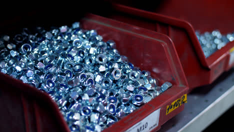 Steel-nuts-for-screws-in-plastic-compartment-of-shop.-Hardware-products-close-up
