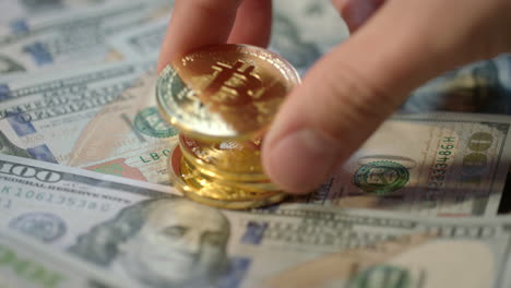 Human-hand-put-gold-bitcoin,-dash-and-ethereum-coins-on-dollar-banknotes