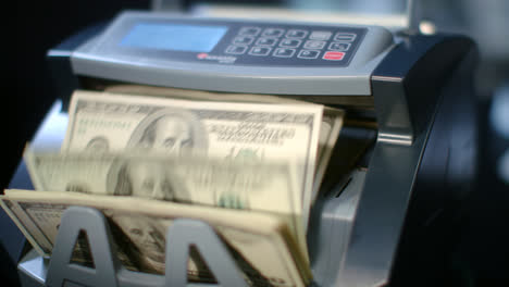Modern-currency-counting-machine-counting-dollar-bills.-Paper-money-calculation