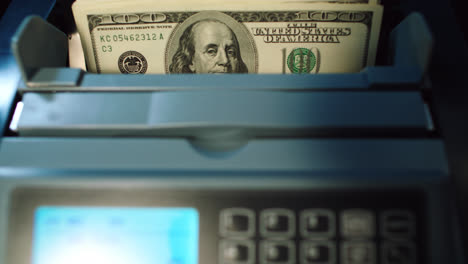 Modern-banking-services.-Cash-counting-machine-counting-100-dollar-bills.