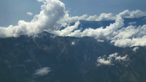Weiße-Wolken-über-Dem-Berg-über-Dem-Flugzeug,-Das-In-Den-Blauen-Himmel-Fliegt.