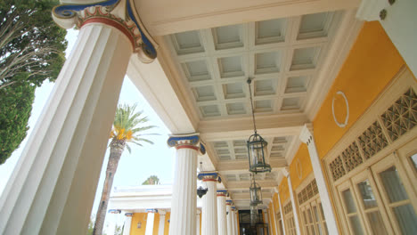 Point-view-lantern-hanging-on-ceiling-columns-building-with-palm-trees