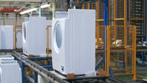 Weißer-Waschmaschinenkörper,-Der-Sich-Auf-Dem-Produktionsförderband-In-Der-Industriefabrik-Bewegt