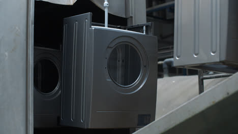 Washing-machine-casing-moving-on-conveyor-line-at-production-plant