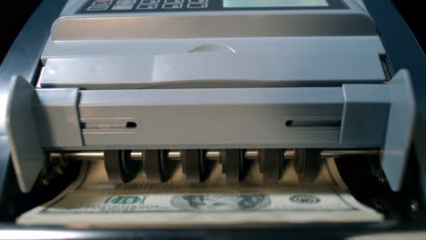 Money-counting-machine.-Cash-money-operation.-Counting-us-dollars-banknotes