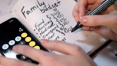 Frau-Berechnet-Familienbudget-Auf-Taschenrechner-Und-Schreibt-In-Notizbuch