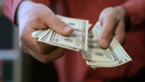 Man-counting-dollar-bills.-Close-up-of-male-hands-count-money-cash