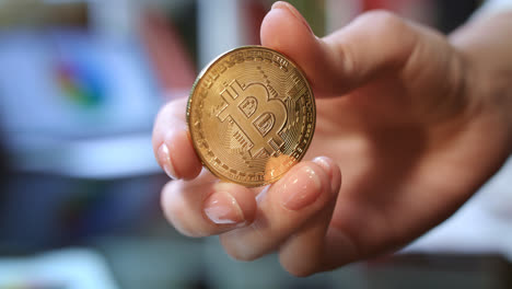 World-cryptocurrency-business.-Woman-hand-holding-gold-bitcoin-coin