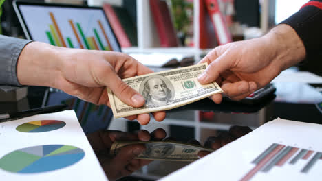 Transfer-money-cash-from-hand-to-hand.-Business-handshake-after-money-deal