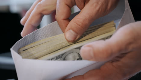 Close-up-of-cash-money-in-envelope-in-hands.-Money-bonus-in-paper-envelope