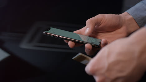 Man-hand-holding-credit-card-and-using-smartphone-for-online-payment