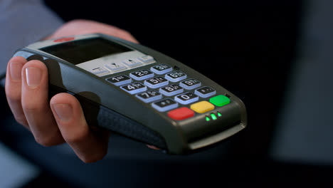 POS-Terminalzahlung.-Menschliche-Hand-Streicht-Kreditkarte-Im-Zahlungsterminal
