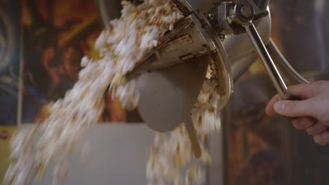 Popcorn-Wird-Aus-Der-Popcornmaschine-Gegossen.-Arbeiter-Kontrollieren-Den-Popcorn-Produktionsprozess