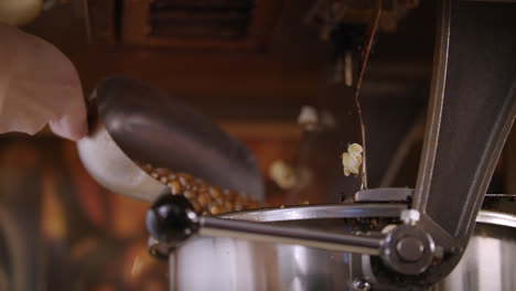Woman-pouring-corn-kernels-in-popcorn-machine.-Process-of-popcorn-production