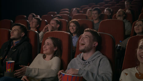 Young-people-laugh-at-comedy-movie-in-cinema-theatre.-People-laughing-at-cinema