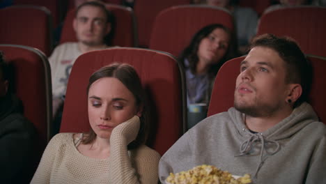 Audience-watching-film-in-movie-theater.-Couple-watching-bored-movie