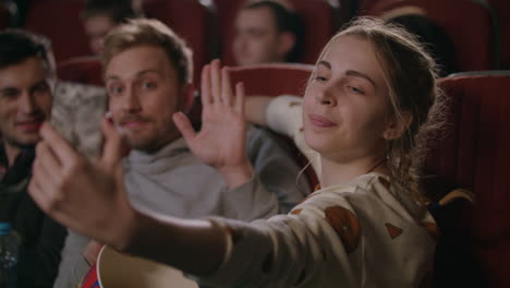 Young-people-having-fun-at-cinema.-Love-couple-making-selfie-photo-in-cinema