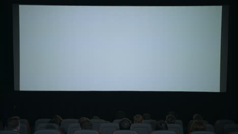 Large-white-screen-in-cinema.-Beginning-film-in-cinema.-Cinema-screen-people