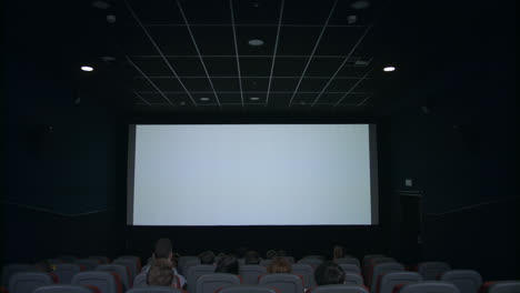 Publikum-Im-Kinosaal-Blickt-In-Erwartung-Der-Filmvorführung-Auf-Die-Weiße-Leinwand