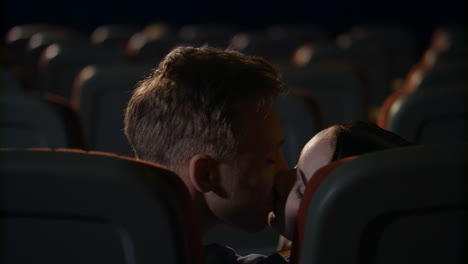 Young-people-kiss-passionately-in-empty-cinema-hall.-Love-couple-kissing