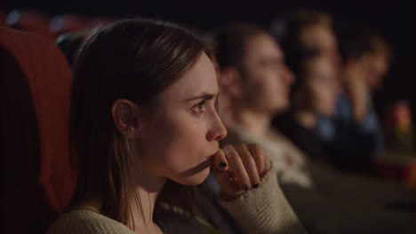 Concentrated-girl-watching-thrilling-movie-at-cinema.-Enjoy-cinema-concept