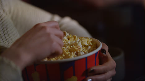 Weibliche-Hand-Nimmt-Popcorn-Aus-Papierbehälter.-Popcorn-Im-Kino-Essen