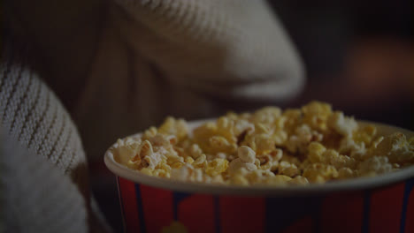 Female-hand-picking-popcorn-from-paper-bucket-closeup.-Eating-pop-corn-at-cinema