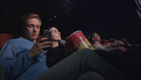 Junger-Mann-Benutzt-Smartphone-Im-Kino.-Junger-Mann-Benutzt-Telefon-Im-Kino