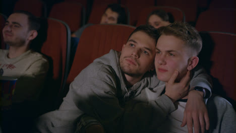 Couple-gays-embracing-in-movie-theater.-Homosexual-men-embrace-in-movie-theatre