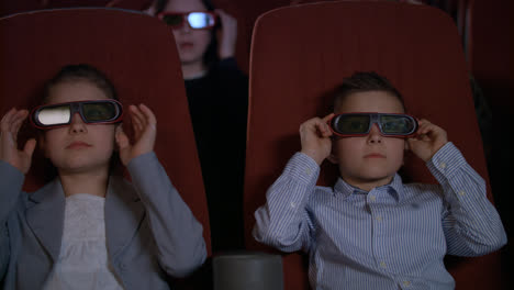 Children-wearing-3d-glasses-at-cinema-chair.-Brother-and-sister-watch-3d-film