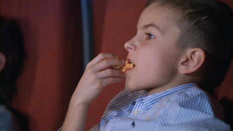 Boy-eating-popcorn-in-cinema.-Teenager-enjoy-cinema-food