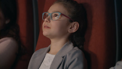 Beautiful-girl-in-glasses-watching-cartoon-film-in-cinema.-Kid-watching-movie