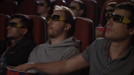 Male-friends-wearing-3d-glasses-in-cinema.-Spectators-get-ready-watch-3d-movie