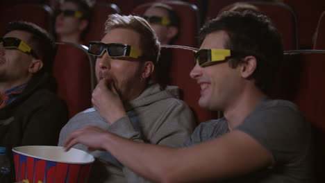 Man-eating-popcorn-in-3d-cinema.-Spectactors-enjoy-cinema-snacks