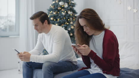 Busy-family-looking-smartphones-in-private-house.-Married-couple-using-phones