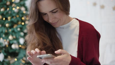 Seriöse-Geschäftsfrau-Sucht-Am-Telefon-In-Weihnachtlich-Dekoriertem-Haus-Nach-Geschenken