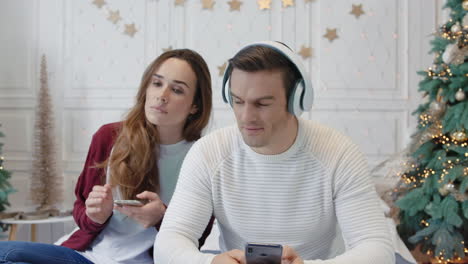 Happy-couple-enjoying-music-in-earphones-together.