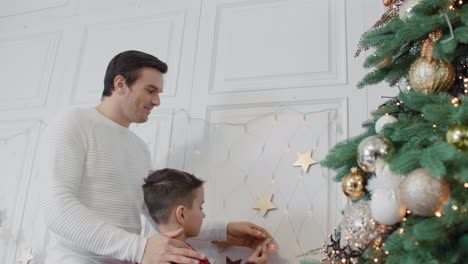 Happy-father-and-son-putting-golden-star-on-wall-in-luxury-room-together.