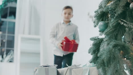 Konzentrierter-Mann-Stellt-Geschenkbox-In-Die-Nähe-Des-Weihnachtsbaums-In-Einem-Luxushaus.