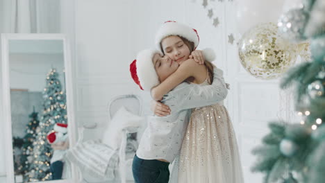 Niños-Sonrientes-Abrazándose-Cerca-Del-árbol-De-Navidad.