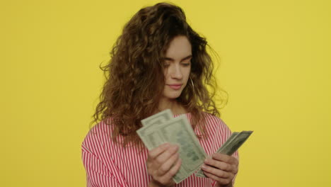 Happy-woman-counting-money-cash-on-yellow-background.-Woman-count-cash-money