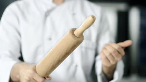 Chef-hands-rolling-roller-at-kitchen.-Closeup-chef-hands-playing-with-roller.