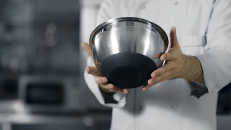 Chef-hands-having-fun-with-steel-bowl-in-slow-motion.-Chef-man-preparing-to-cook