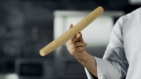 Chef-playing-with-roller-at-workplace.-Closeup-man-hands-twist-roller-at-kitchen