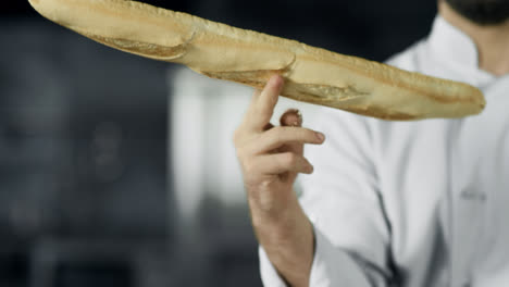 Koch-Hat-Spaß-Mit-Französischem-Brot-In-Der-Küche.-Nahaufnahme-Von-Mannhänden,-Die-Mit-Brot-Spielen