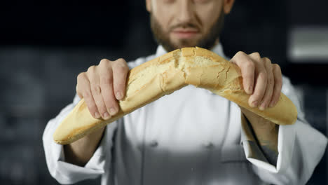 Koch-Bricht-Französisches-Brot-In-Zeitlupe.-Nahaufnahme-Von-Bäckerhänden,-Die-Brot-Brechen.